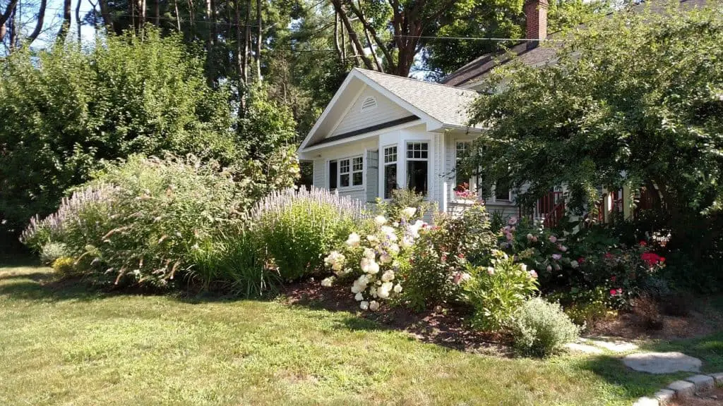 A house with lots of flowers on the article Best Flowers for a Beautiful Front Yard